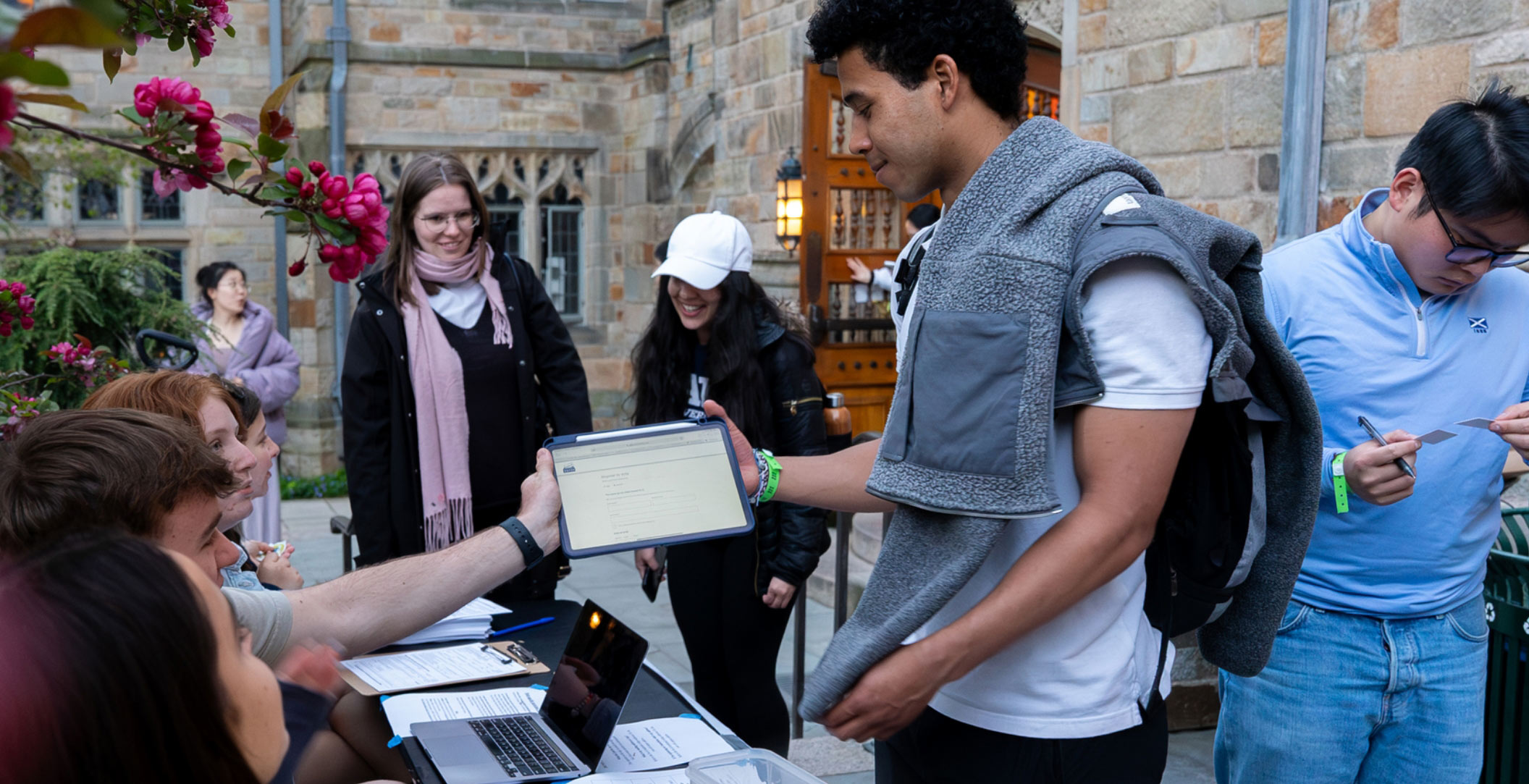 Student using TurboVote on a table to change registration information on Yale's campus.